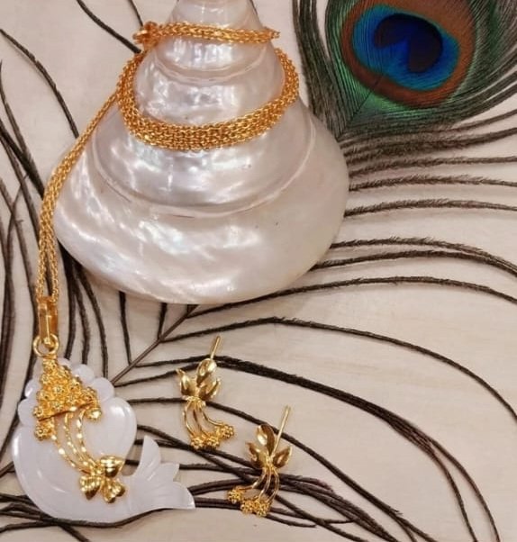Handmade gold-finished shell jewellery and mangalsutra on a natural shell